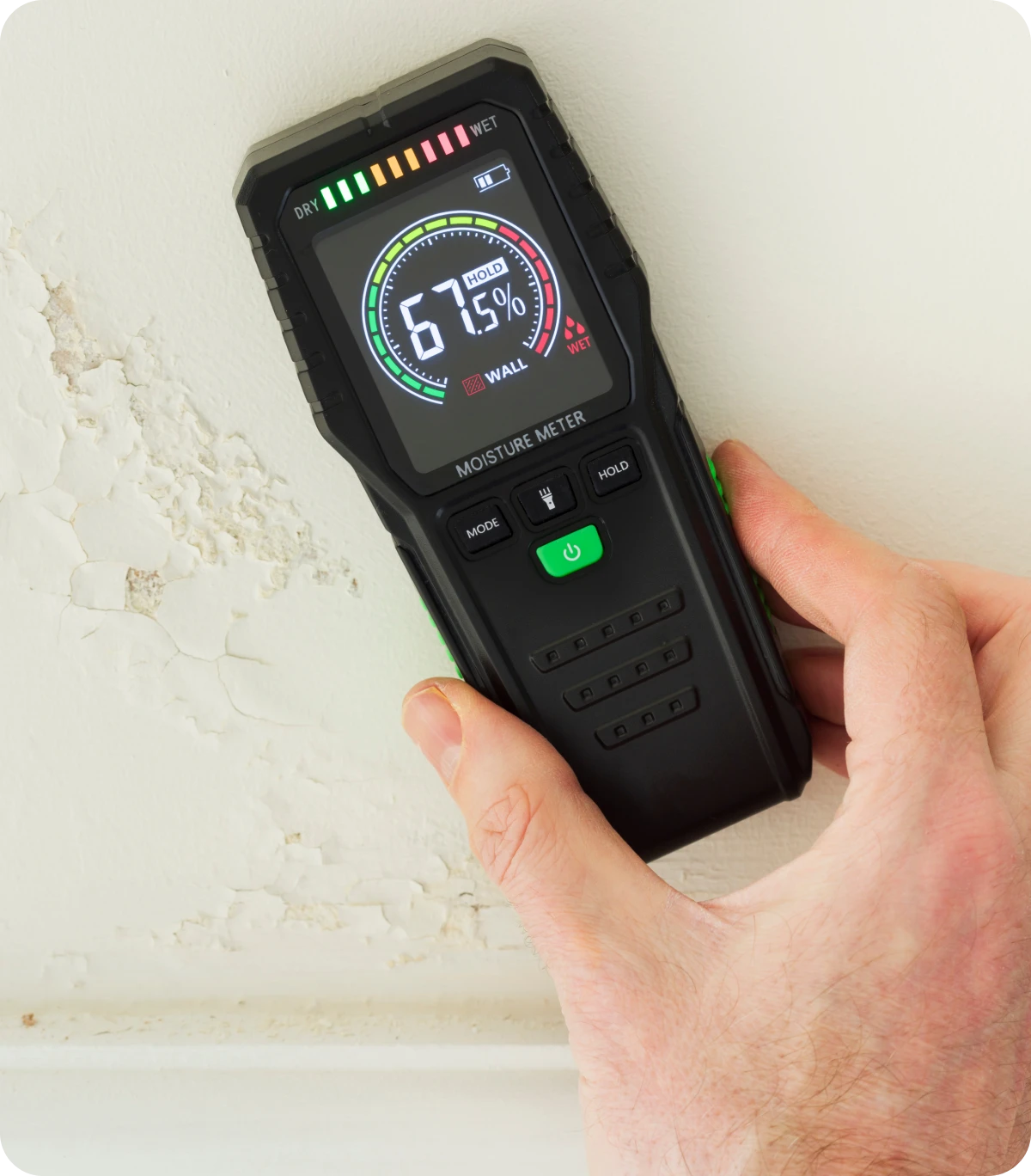 Hand holding a digital moisture meter