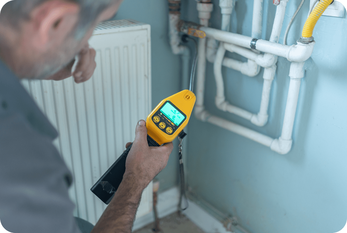 Man inspecting pipes with device
